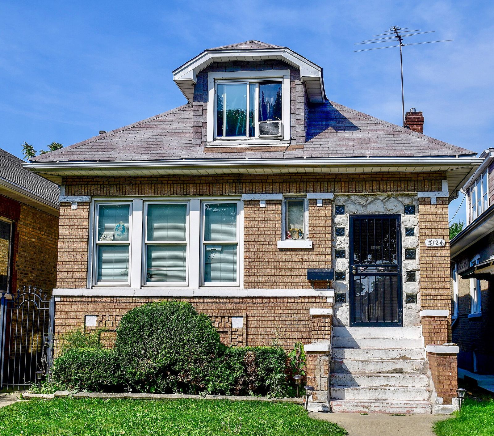 Brick bungalow with a new shingle roof and a dormer